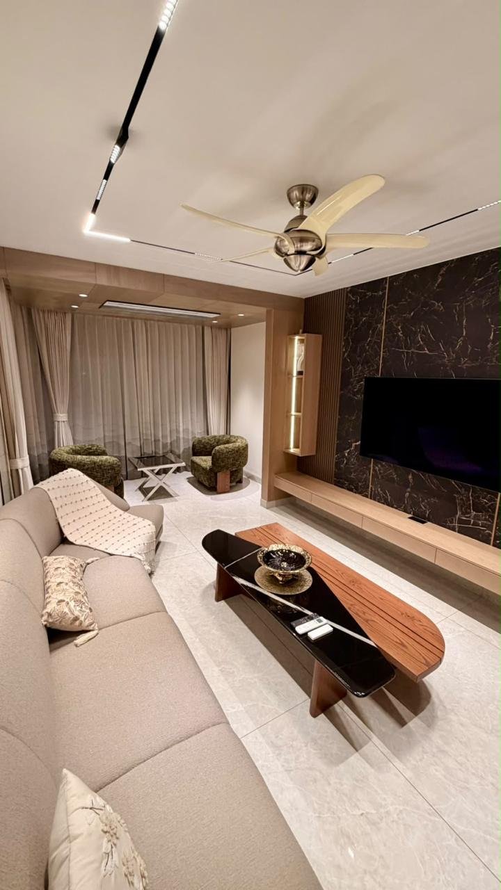 Living room with pale sofa, wood coffee table and dark television wall