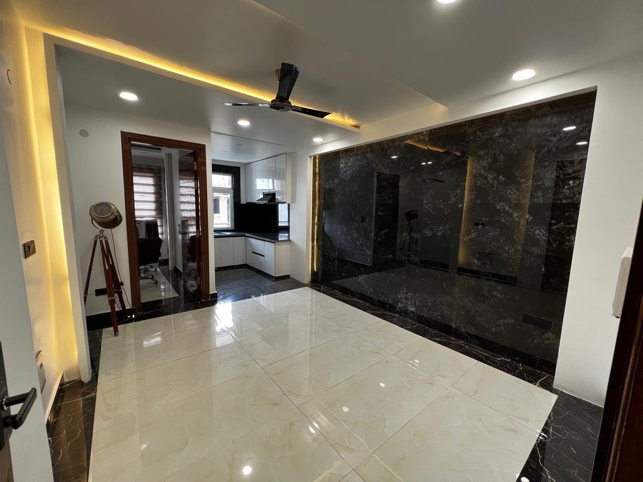 Living area with a dark stone feature wall beside the kitchen