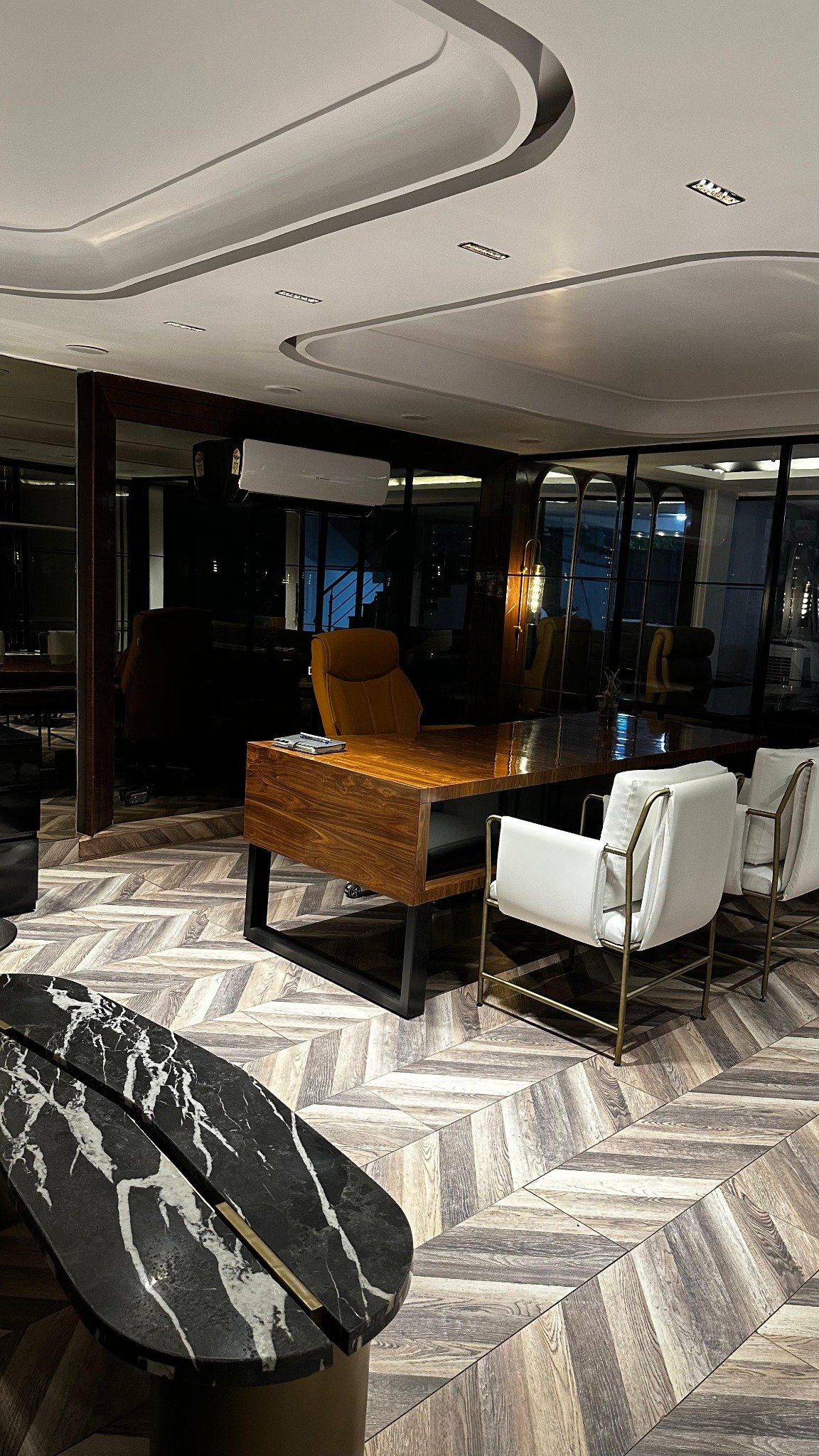 Executive office with timber desk, visitor chairs and glazed walls