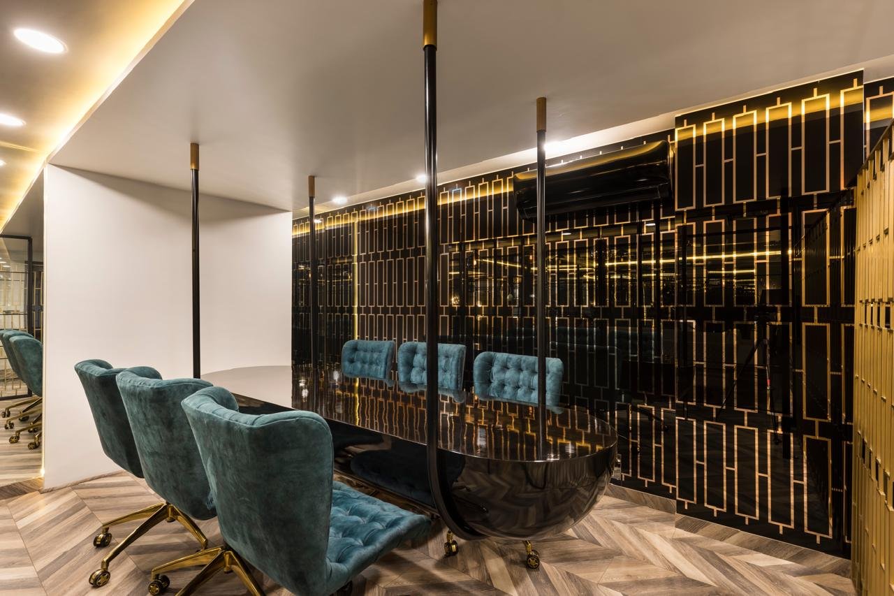 Office meeting nook with teal chairs and a gold divider