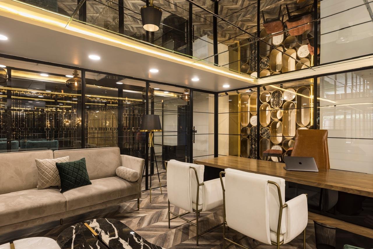 Office lounge with cream sofa, glass partition and seating area